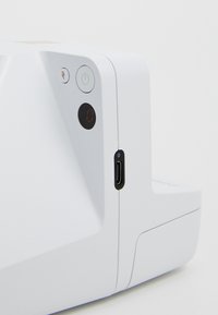 Dispositif blanc au design angulaire, comprenant un bouton d'alimentation, des voyants lumineux et un port USB-C sur le côté, texture mate lisse.