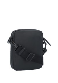 Sac bandoulière noir en tissu durable, de forme rectangulaire, avec une sangle ajustable et une fermeture éclair accompagnée d'accents en métal.