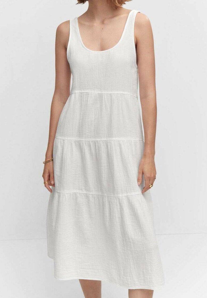 Abito bianco in cotone con scollatura a girocollo, design senza maniche, volant a strati e una finitura leggermente testurizzata. Lunghezza al ginocchio. Accenti semplici.
