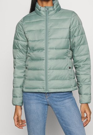 Giacca imbottita in verde chiaro con colletto alto, chiusura frontale a zip e cuciture orizzontali. Presenta tasche laterali e una texture liscia.