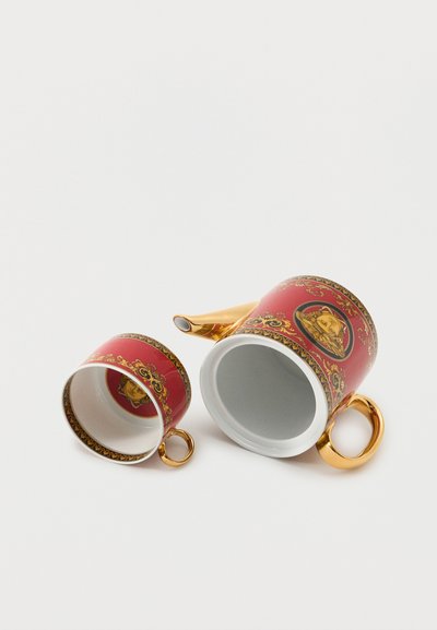 Ensemble de théière et tasse en porcelaine rouge et or, présentant un motif détaillé de visage classique et des bordures décoratives ornées sur fond blanc.