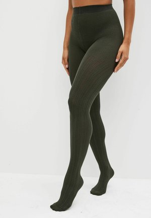 Olivgrüne Rippstrumpfhosen mit einem strukturierten Fischgrätmuster und einem hohen Bund. Hergestellt aus einem dehnbaren, atmungsaktiven Material.