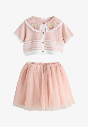 Rózsaszín kötött rövid ujjú kardigán gombos elülső résszel és virágos gallérral, csillogó rózsaszín tüll szoknyával, gumis derékrésszel.