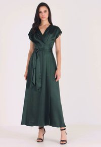 Green satin wrap dress with short sleeves, a V-neckline, and a self-tie belt. Flowy silhouette reaching mid-calf, smooth texture.