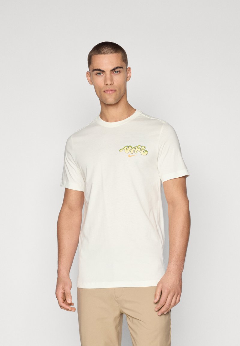 Camiseta blanca de algodón con mangas cortas, que presenta un logo bordado multicolor en el pecho. Textura suave y escote redondo.