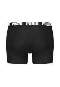 Schwarze Boxer-Briefs aus Baumwolle mit einem umgeschlagenen elastischen Bund, der das weiße "PUMA"-Logo trägt. Glatte Textur und enganliegendes Design.