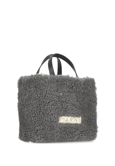 Borsa grigia a pelo lungo realizzata in tessuto testurizzato con manici in pelle nera e forma rettangolare; presenta un'etichetta crema con il testo "MARNI".