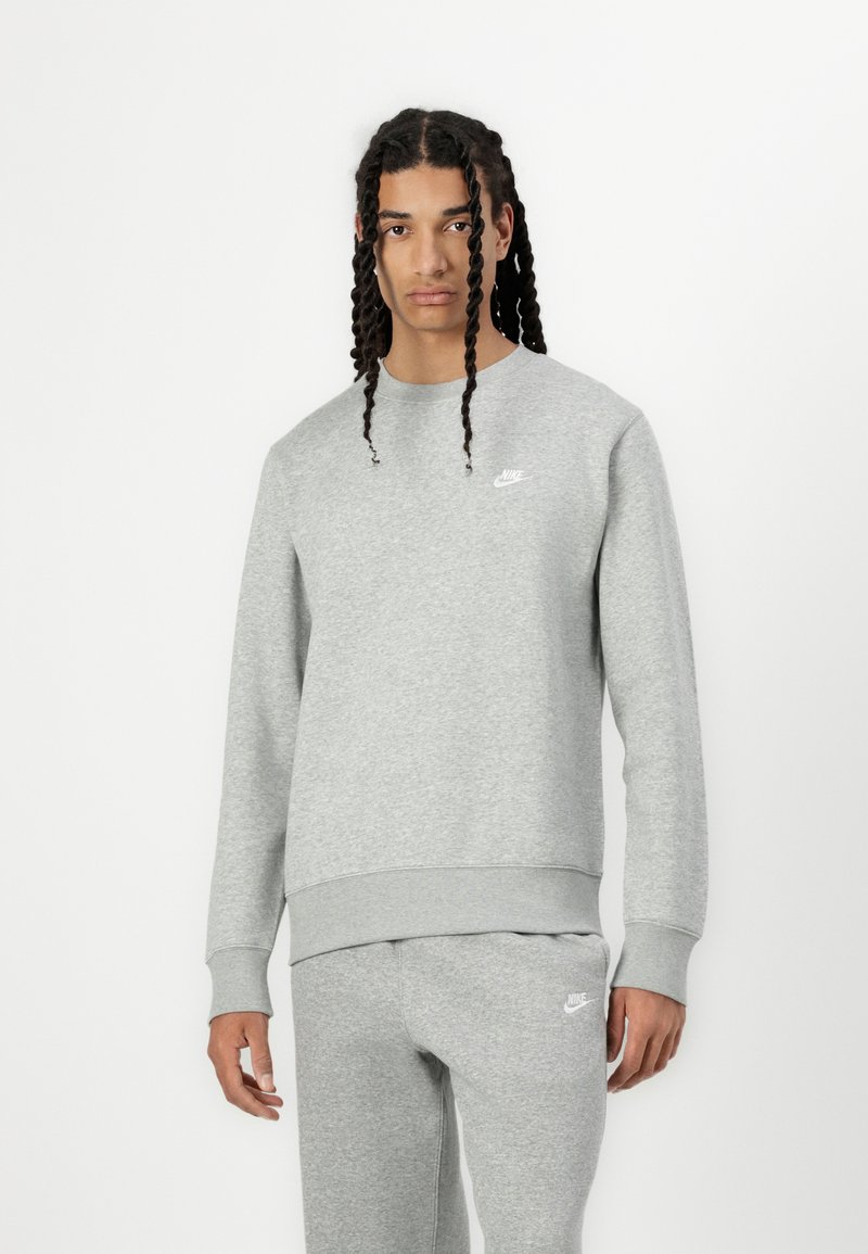 Sivi Nike dukserica sa okruglim izrezom, rebrastim manžetama i porubu, sa malim bijelim logotipom na lijevoj strani prsnog koša. Mekana tekstura i ležeran kroj.