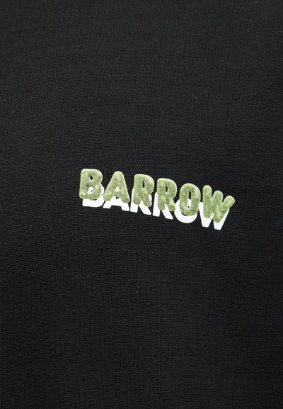 Μαύρο ύφασμα με τη λέξη «BARROW» κεντημένη με υφή σε πράσινα και λευκά γράμματα, τοποθετημένα σε ελαφριά ανοδική καμπύλη.