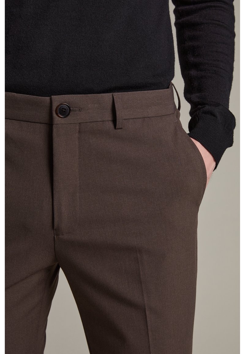 Bruna skräddarsydda byxor med en mjuk textur, bältesöglor och en framficka. Har en enkel knappstängning och en rak passform.