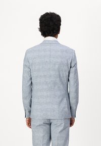 Light blue plaid suit with a structured design. The material appears woven, featuring subtle color variations and a smooth texture.