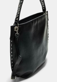 Borsa a mano in pelle nera con una finitura testurizzata, dotata di una tracolla borchiata, hardware argentato e un interno spazioso. Inclusa una tracolla laterale regolabile.