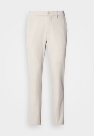 Beżowe spodnie w wąskim kroju, z zapięciem na guzik z przodu, płaskim przodem i prostymi nogawkami, wykonane z gładkiej mieszanki bawełny.