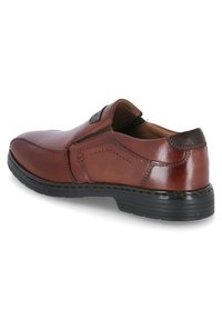 Bruine leren schoen met een ronde neus, een elastische zijkant voor gemakkelijk aan- en uittrekken, contrasterende stiksels en een lichte zwarte rubberen zool.