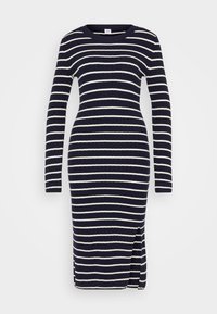 Ribbad trikåklänning i marinblått med vita horisontella ränder, långa ärmar, rundad halsringning och detalj med slits på sidan. Mjuk textur.