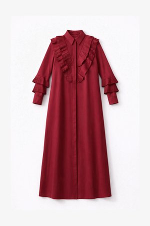 Pitkä viininpunainen mekko, jossa on terävä kaulus, napitettu etuosa, rintakehällä laskostettu röyhelöreunus ja kerrokselliset laskostetut röyhelöhihansuut pitkissä hihoissa.