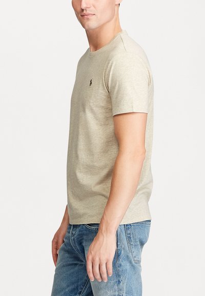 Beige short-sleeve t-shirt made of soft cotton, featuring a small logo on the chest, round neckline, and a relaxed fit.