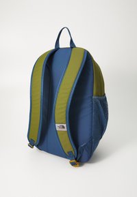 Σακίδιο πλάτης με μπλε ύφασμα σώματος και πράσινες μαξιλαρωμένες ιμάντες, καθώς και τσέπη από δίχτυ στο πλάι. Περιλαμβάνει λαβή στο πάνω μέρος και ρυθμιζόμενους ιμάντες.