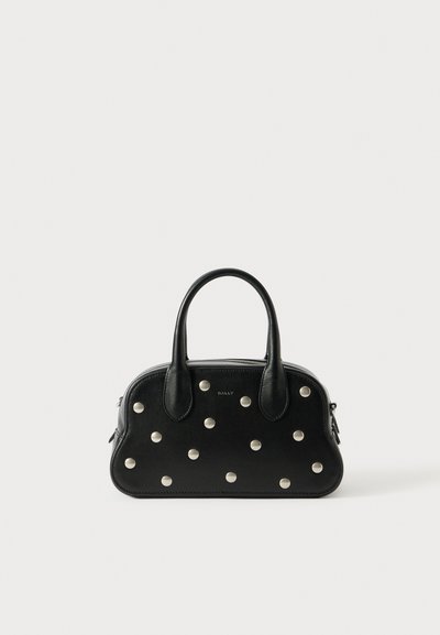 Sac à main en cuir noir de forme arrondie, avec des clous en argent répartis de manière uniforme sur le devant, deux poignées et une fermeture éclair.