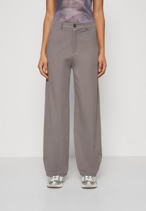 Pantaloni ampi grigi chiari con chiusura a bottone, realizzati in tessuto morbido. Presentano una singola cucitura frontale e un fit rilassato.