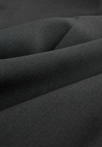 Material textil de culoare neagră, cu o textură netedă, prezentând pliuri care ilustrează modul în care se drapajează. Materialul pare moale și ușor elastic.