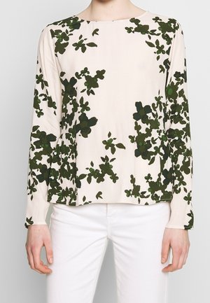 Haut à manches longues beige clair avec motif floral vert foncé. Texture douce et coupe décontractée, avec un col rond et un ourlet droit.
