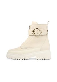 Bottine chunky en cuir blanc avec fermeture éclair sur le côté, large sangle et boucle métallique circulaire, surface texturée et semelle épaisse à motifs.