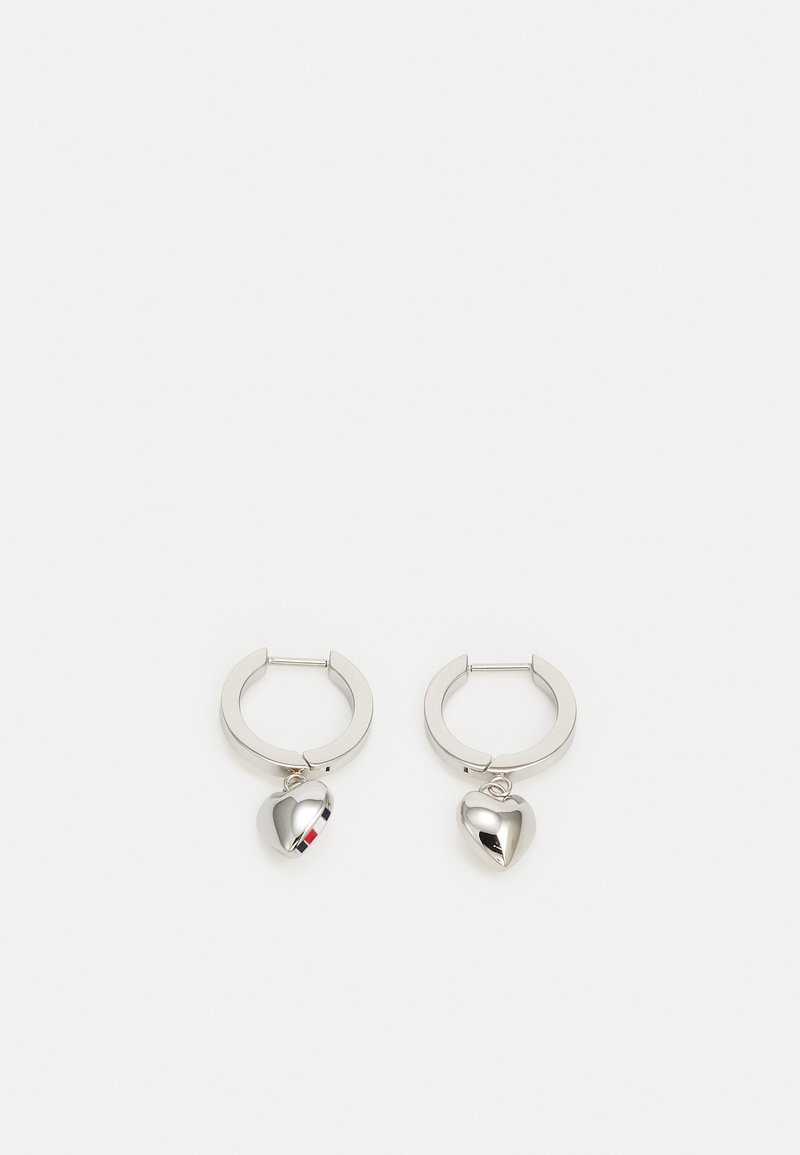 Pendientes de aro de plata con un charm en forma de corazón brillante, que presenta una pequeña franja de color en un lado. Textura suave y diseño contemporáneo.