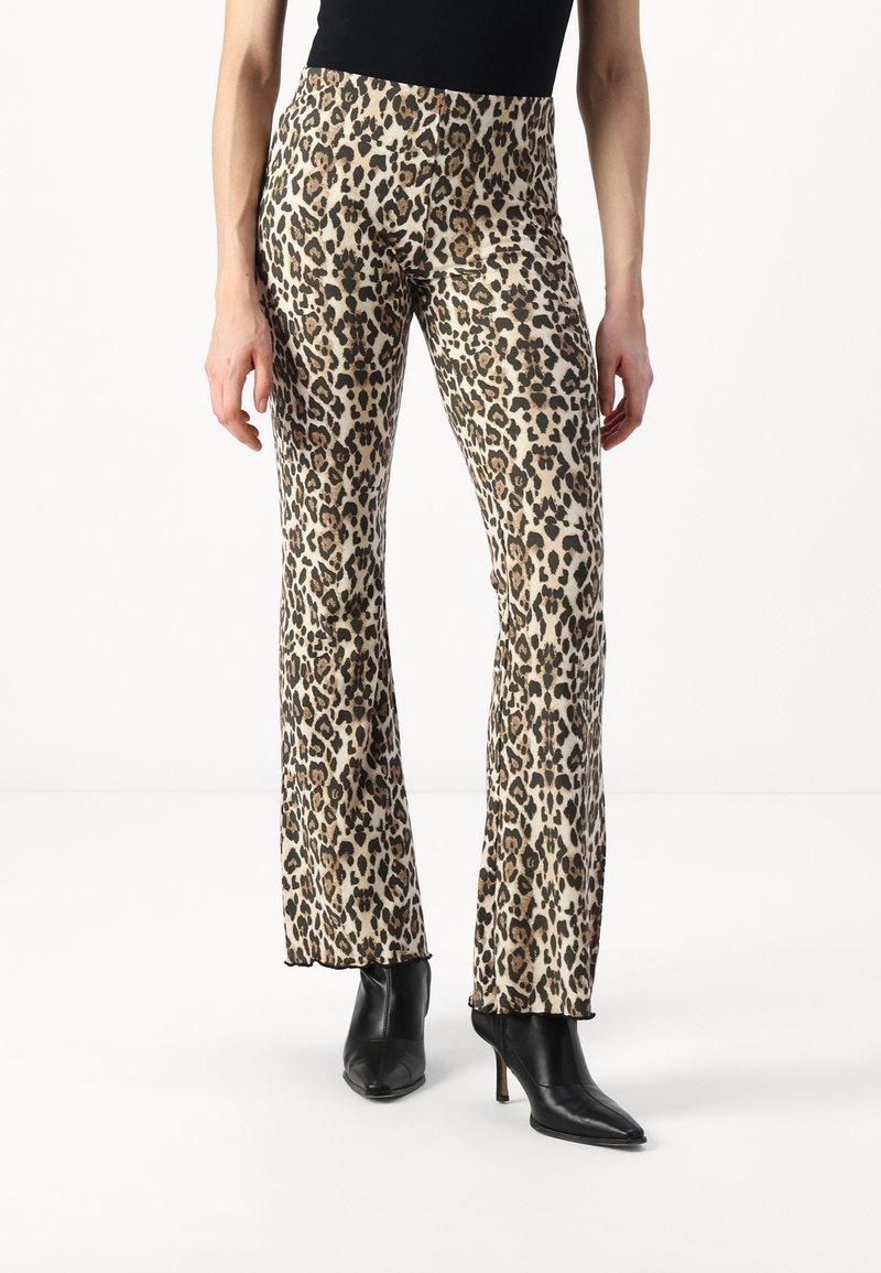 Bež i crne leopard uzorak trapez hlače s glatkom teksturom i visokim strukom, uparene s crnim cipelama na visoku petu.