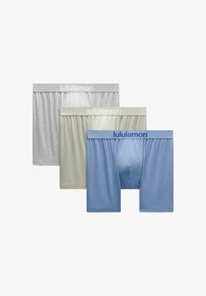 Drie herenboxers in grijs, lichtgroen en blauw, elk met een elastische tailleband met het merk "lululemon".