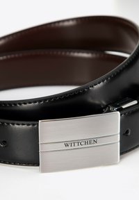 Zwarte leren riem met glanzende zilveren metalen gesp, voorzien van het gegraveerde "WITTCHEN"-logo. Gladde textuur en strakke lijnen.