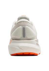 Vit idrottssko med en texturerad ovandel, en dämpad häl och orange sula. Har en grå accent på hälpartiet.
