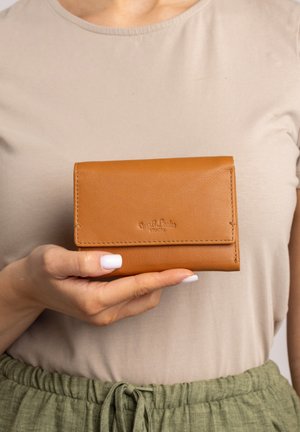Tan leather wallet with a sleek design, fold-over closure, and embossed logo. Features neat stitching and a smooth texture.