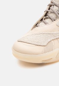 Beige sneakers med overdel i læder og tekstureret ruskind, rund tå, perforerede detaljer og en gennemsigtig gummi sål.