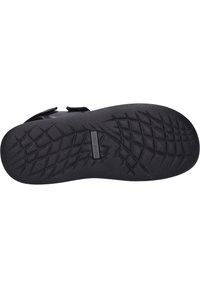 Suola di scarpa in gomma nera con un motivo testurizzato e un battistrada per la presa. Include un logo impresso al centro con un bordo liscio.