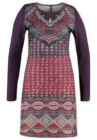 Langarm jurk met een geborduurd lijfje met geometrische patronen in roodtinten en paars, overgaand naar strepen aan de zoom. Van katoen.
