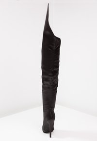 Zwarte over-de-kniehoge laars van satijn met een spitse silhouet, hoge stilettohak en een gladde textuur. Bevat geen zichtbare sluitingen.