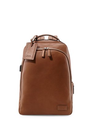Brown leather backpack with front zip pocket, top handle, and attached rectangular leather tag on a white background.
