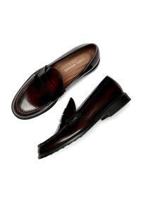 Bruine leren loafers met een gladde afwerking, met een decoratieve band, ronde neus en contrasterende stiksels langs de zool.