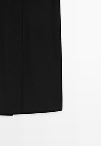 Black skirt featuring a straight cut, smooth texture, and stitching details. Fabric appears lightweight with a subtle sheen.