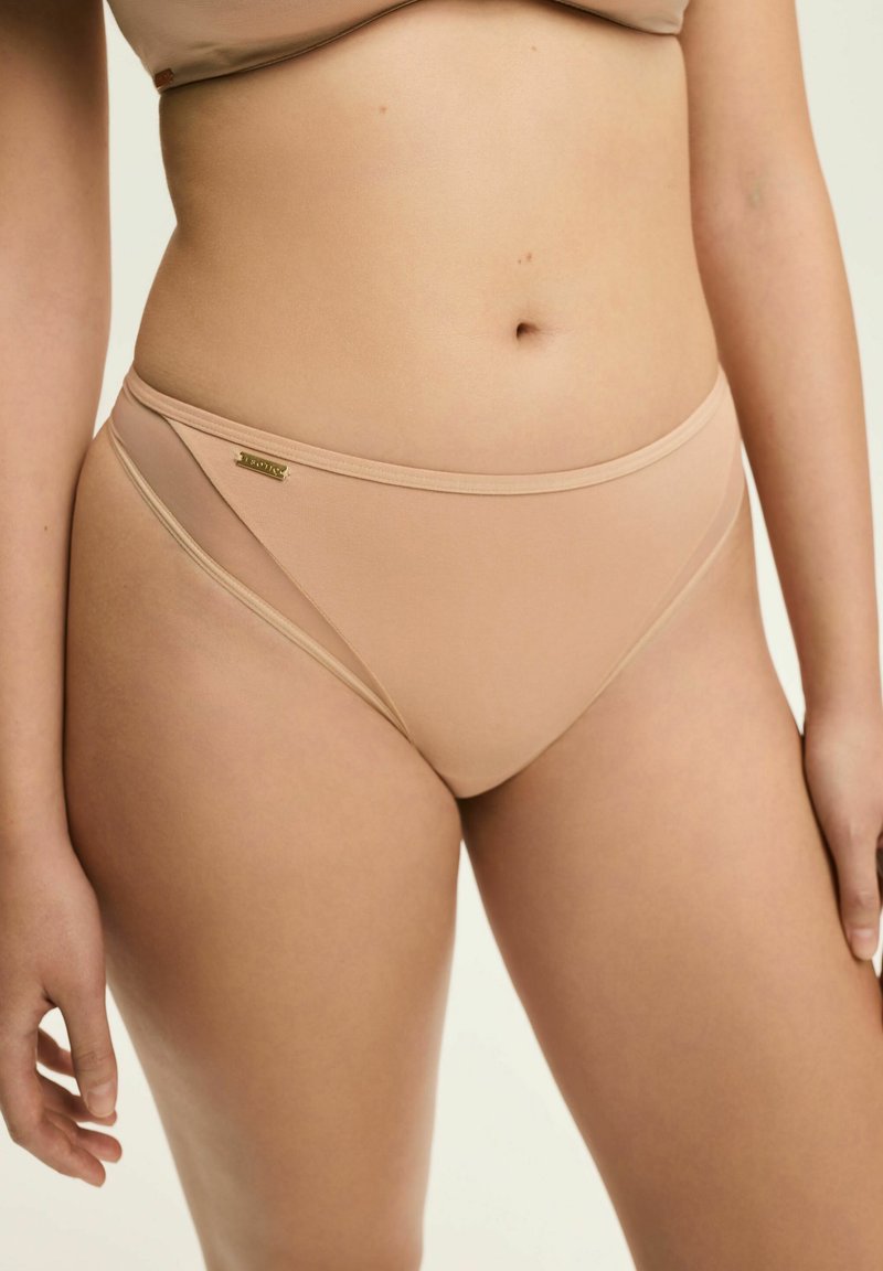 Beżowe majtki bikini o gładkiej fakturze, niskim stanie, minimalnych szwach i subtelnym złotym detalem po boku.