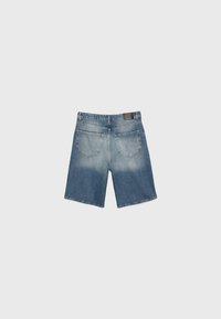 Shorts en denim de couleur bleu moyen, à coupe droite, avec des coutures visibles et deux poches arrière présentant un léger dégradé.