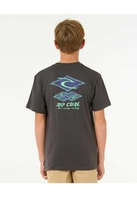 Camiseta de manga corta, de color gris oscuro, hecha de algodón. Presenta un logo de marca de surf colorido y elementos de diseño en la parte posterior. Textura suave.