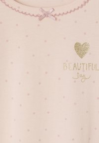 Helles rosa Kurzarmoberteil mit kleinen rosa Punkten, einem gewellten Ausschnitt, einer rosa Satin-Schleife und goldenem Glitzerschriftzug: „Schöner Tag.“