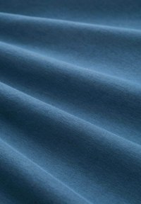 Tessuto in un profondo tono blu, caratterizzato da una texture morbida con pieghe visibili e una superficie liscia; assente di motivi o dettagli.