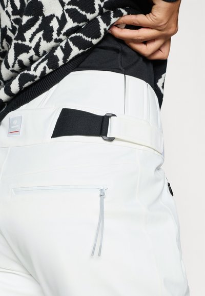 Bela hlače z gladko teksturo, opremljene s črnim nastavljivim trakom, žepom z zadrgo in logotipno etiketo blizu pasu.