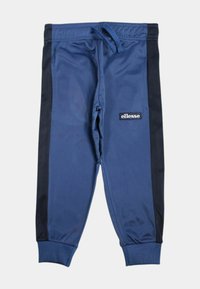 Pantalon de jogging bleu avec panneaux latéraux noirs, poignets côtelés, taille à cordon de serrage et logo "ellesse" blanc sur la cuisse droite.