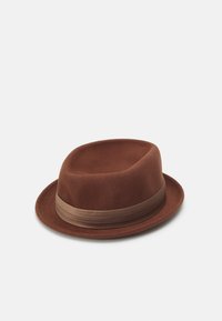 Brun filt fedora-hatt med ett smalt brunt band. Hatten har en rundad topp och en bred, något uppvikt skärm.