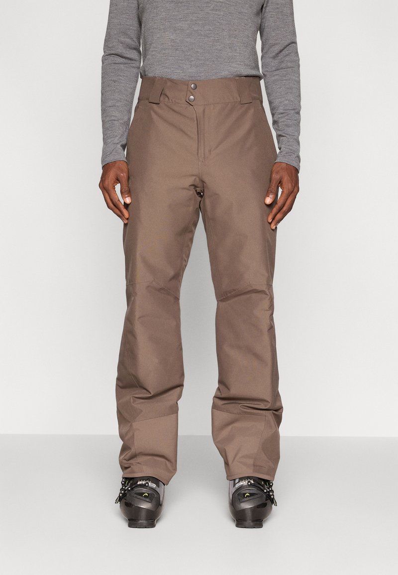 Hnedé snehové nohavice vyrobené z odolného materiálu, s rovnými nohavicami, dvoma prednými gombíkmi a uvoľneným strihom okolo nôh.
