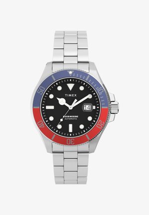 Rustfrit stålur med sort urskive, rød og blå bezel samt sølvfarvede ledninger. Funktionerne inkluderer hvide timemarkerings og en datovisning.